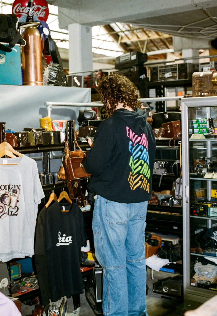 Customer browsing vintage cameras and secondhand photography gear at Old Skool Optics inside My Dead Grandpa Adelaide.