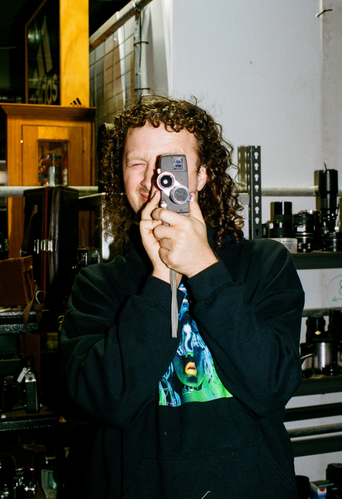 Customer holding a vintage film camera at the Old Skool Optics space inside My Dead Grandpa Adelaide.