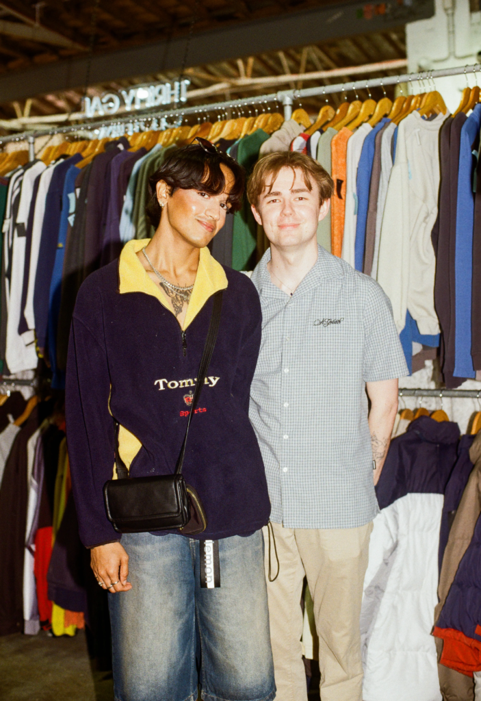 Two shoppers wearing vintage Tommy Sports and checked shirts in front of clothing racks.