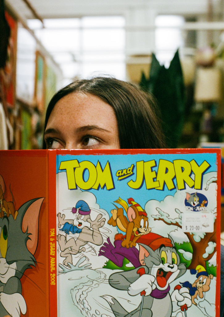 Reader holding a Tom and Jerry book at Better Off Read in My Dead Grandpa Adelaide