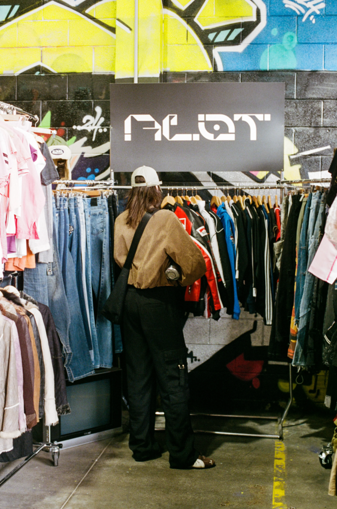 Shopper browsing ALOT vintage clothing racks under the ALOT sign at My Dead Grandpa Adelaide.