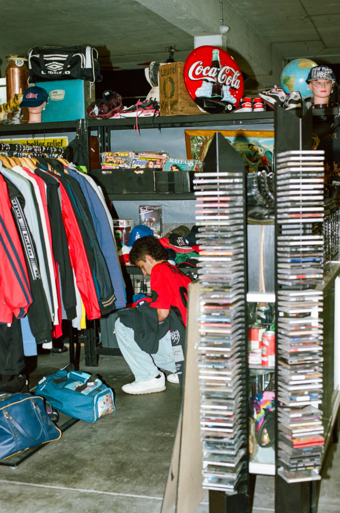 Scrapdogs vintage stall with clothing racks, CDs, caps, shoes and retro advertising signs in Adelaide