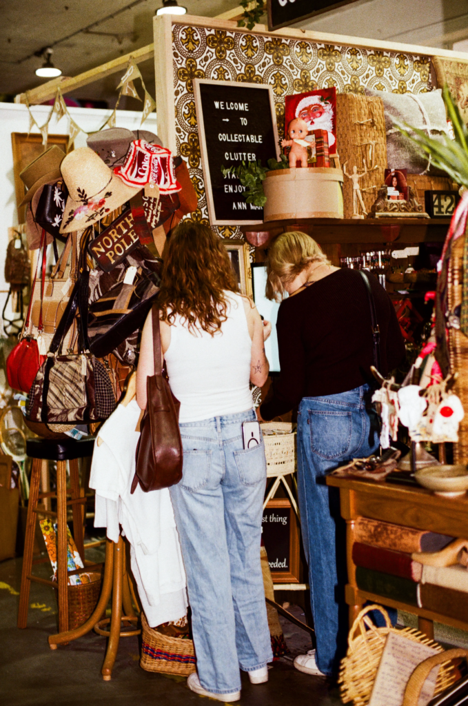 Shoppers browsing hats, bags and retro collectables at Collectable Clutter inside My Dead Grandpa Adelaide.