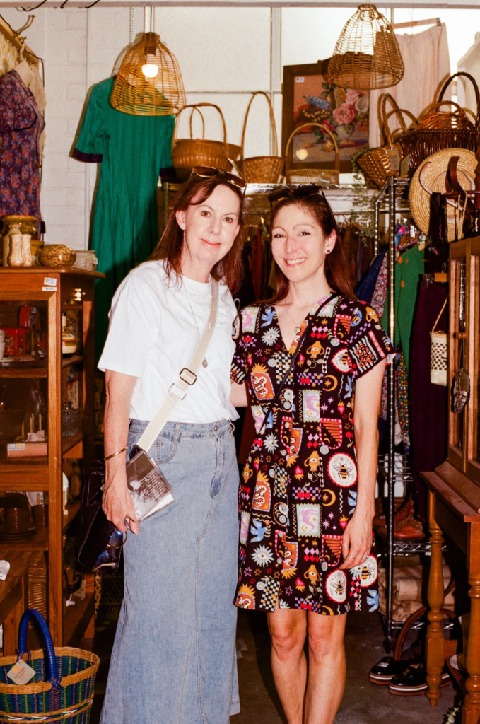 Two shoppers standing among vintage clothing, baskets and retro homewares at Wattlebird Bazaar Adelaide.