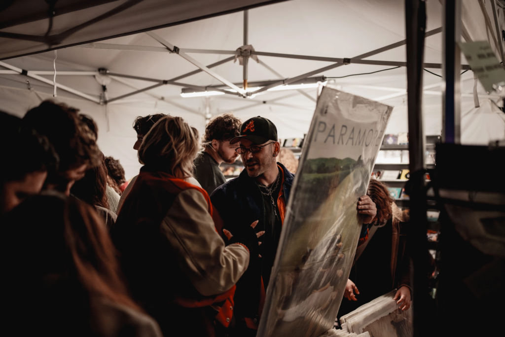 Customer holding a large vintage Paramore poster at Deadbeat Sounds in Adelaide