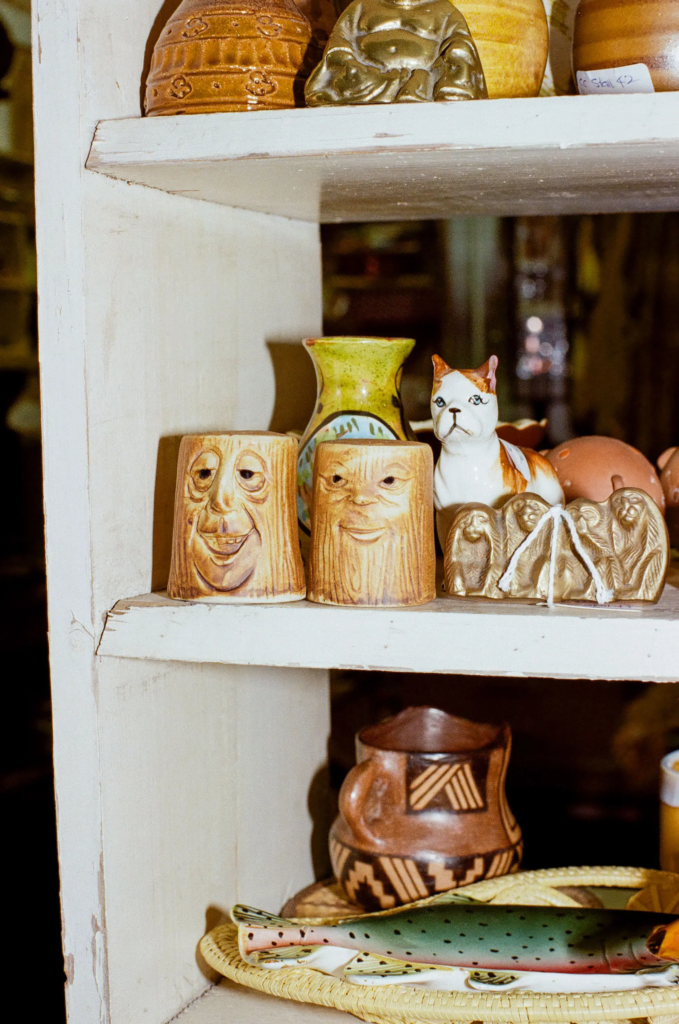 Quirky vintage ceramic figures and cat ornament on a shelf at Collectable Clutter Adelaide.