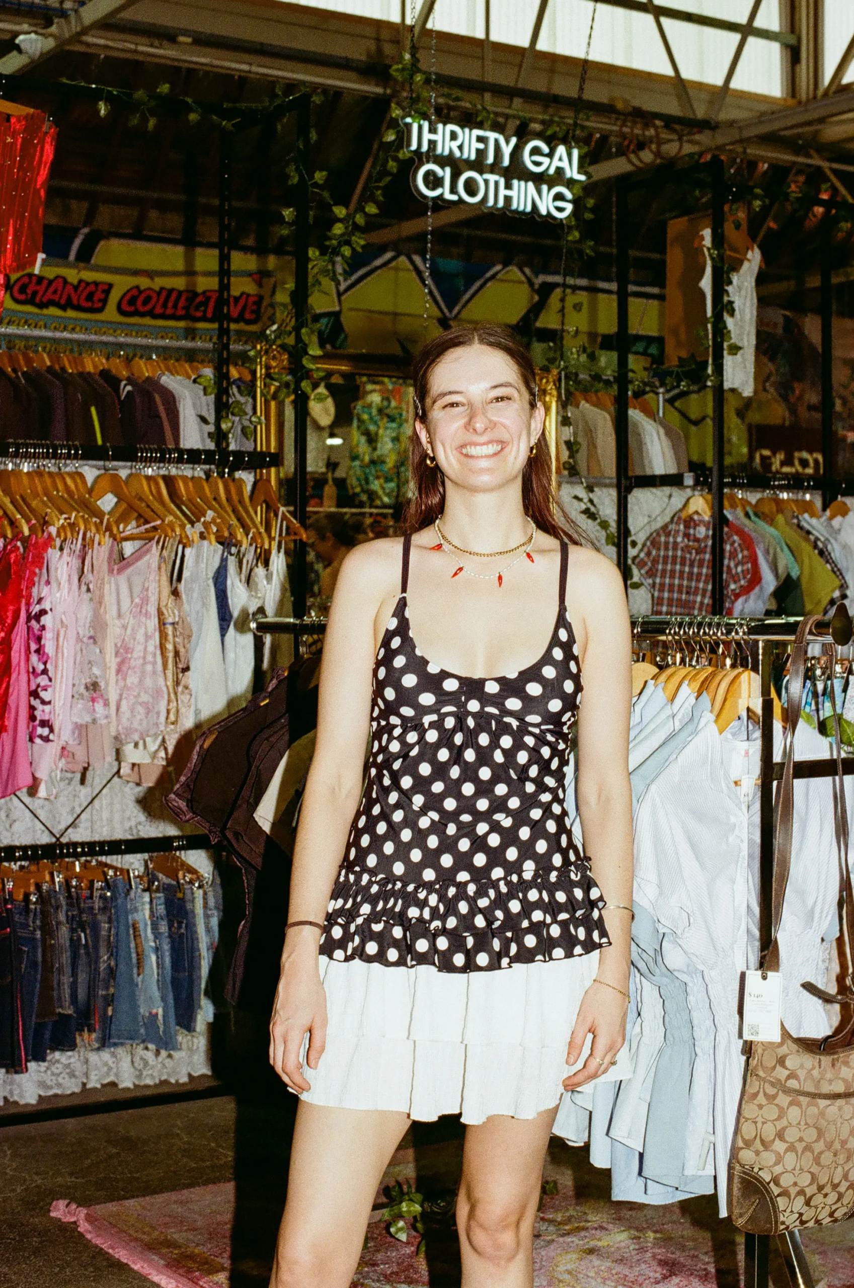 Liv, owner of Thrifty Gal, standing in front of her Y2K preloved clothing stall at My Dead Grandpa Adelaide.