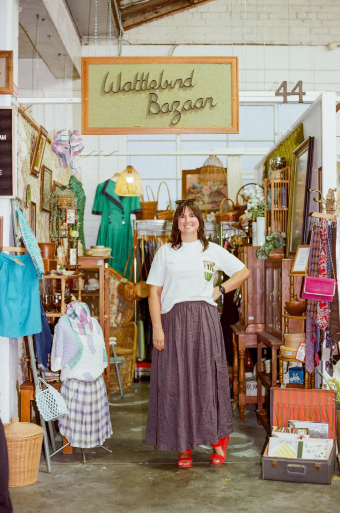 Tait Brimacomb, owner of Wattlebird Bazaar, standing in her vintage homewares and fashion stall at My Dead Grandpa Adelaide.