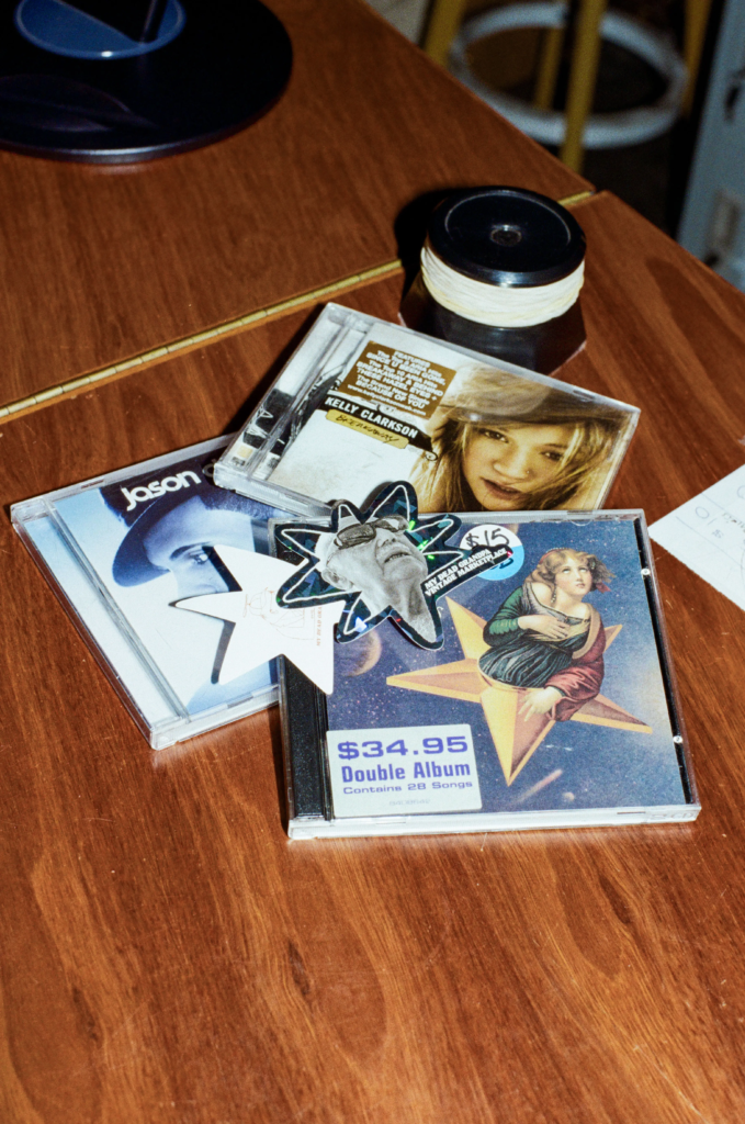 Assorted pre-owned Y2K pop CDs displayed on a wooden table at Deadbeat Sounds