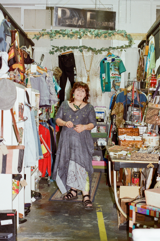 Jodie Shoobridge, owner of Pricilla’s Emporium, standing inside her handmade upcycled stall at My Dead Grandpa.